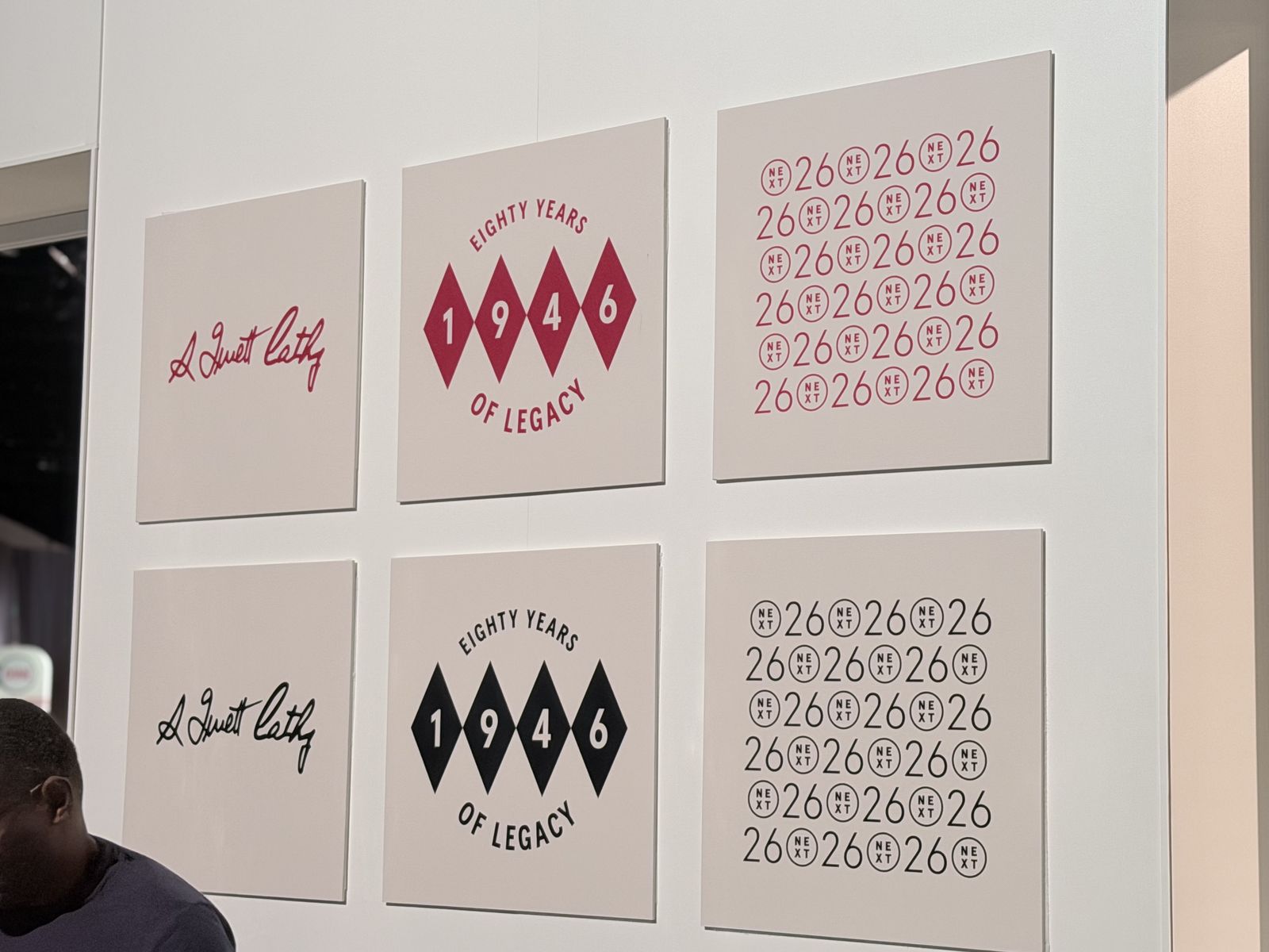 Wall of framed letterform and numeral artwork proofs in red and black