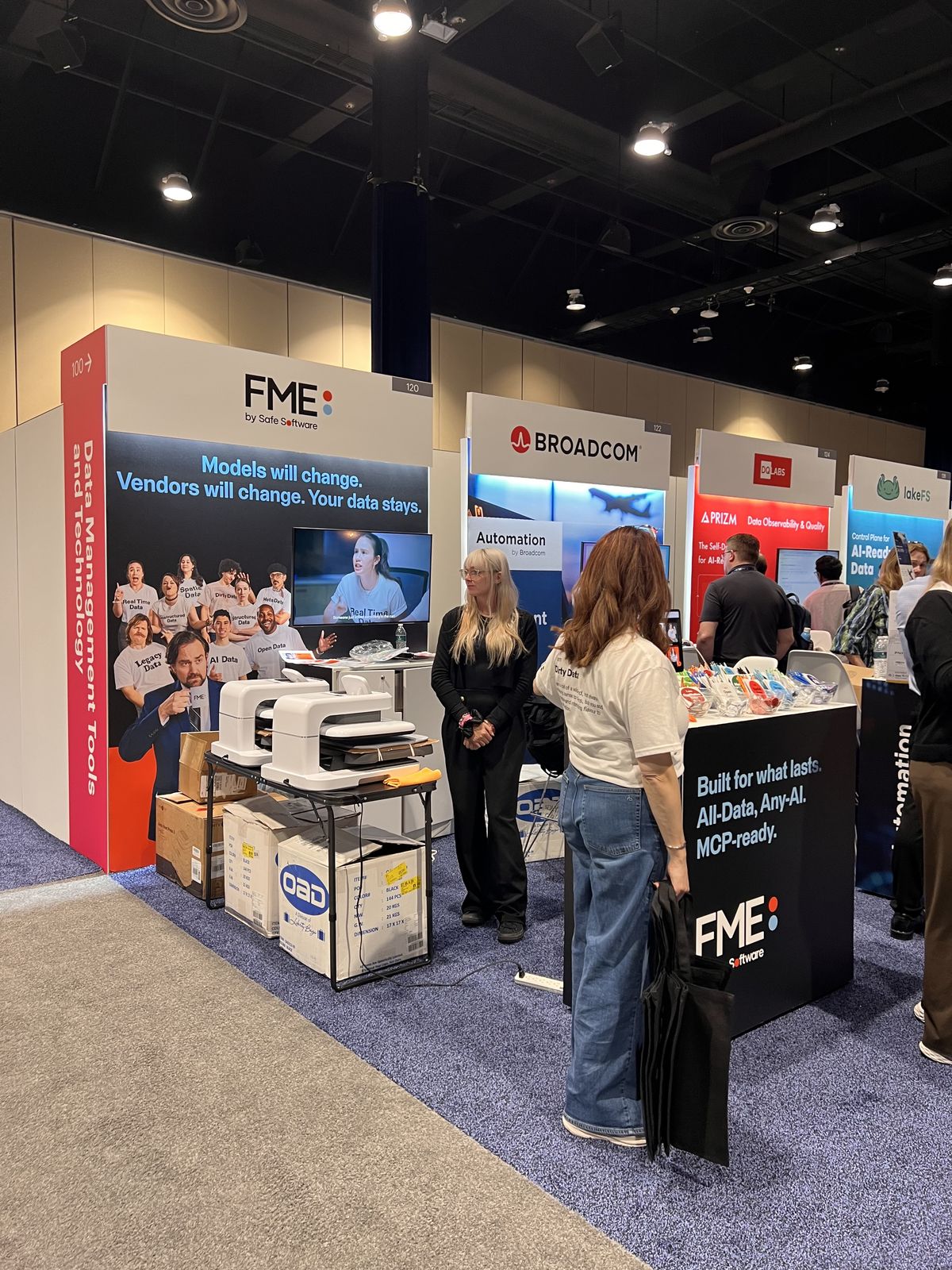 Heat presses set up inside a trade show booth with staff ready for attendees